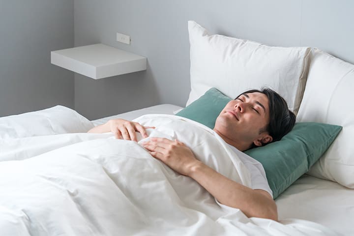 ベッドで眠る男性